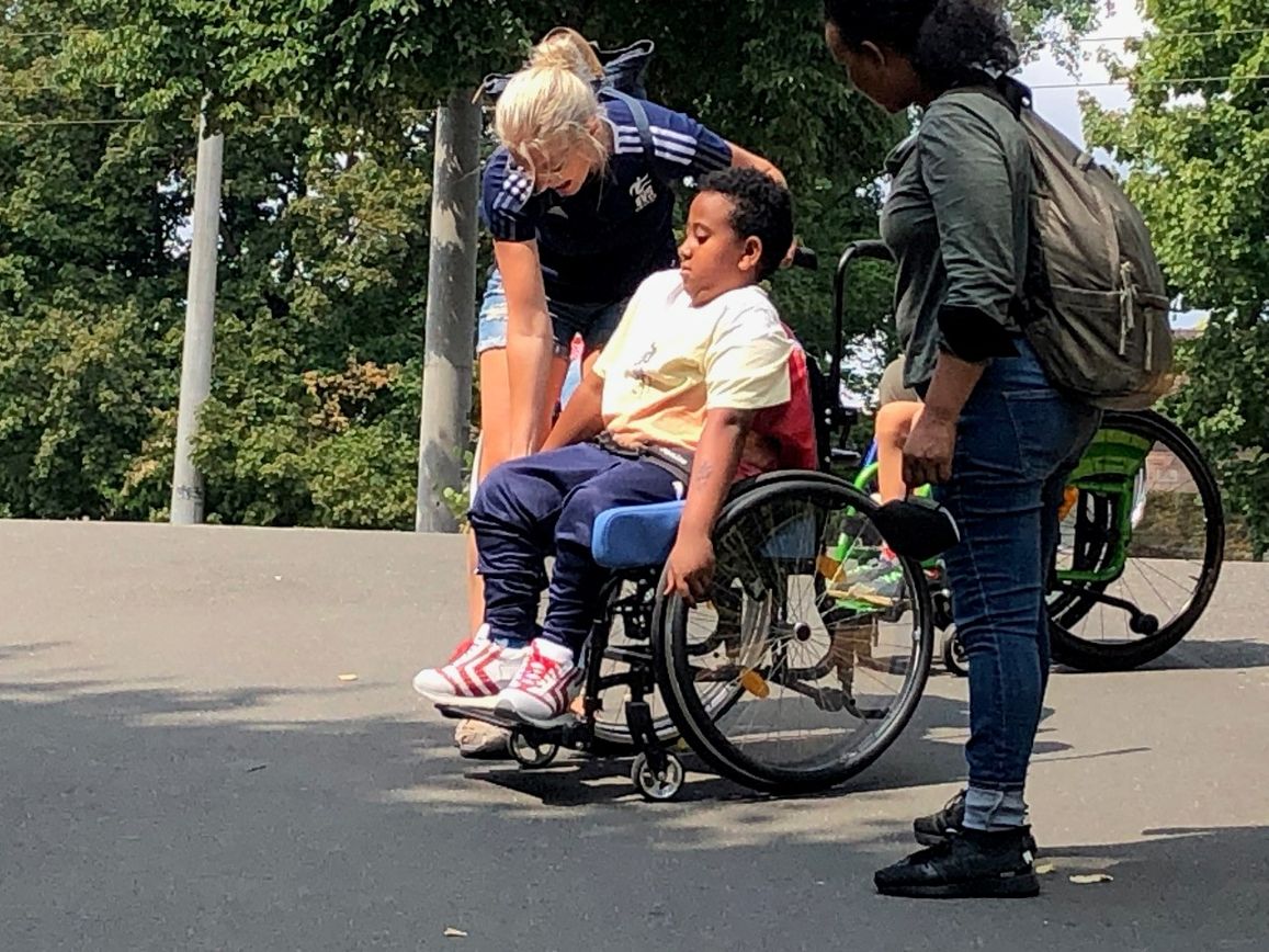 Romy hilft bei dem Einstellen des Rollstuhls